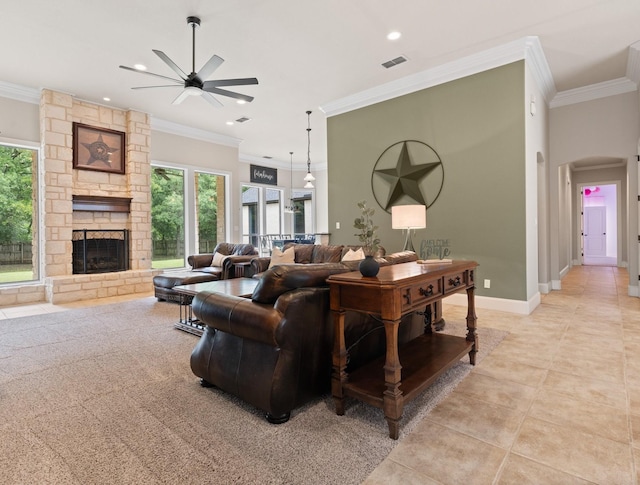 living area with ceiling fan, plenty of natural light, crown molding, a stone fireplace, and recessed lighting
