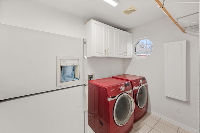 laundry room with light tile patterned floors, separate washer and dryer, visible vents, baseboards, and cabinet space