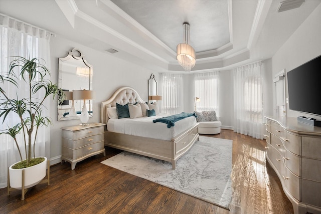 bedroom featuring a raised ceiling, visible vents, crown molding, and wood finished floors