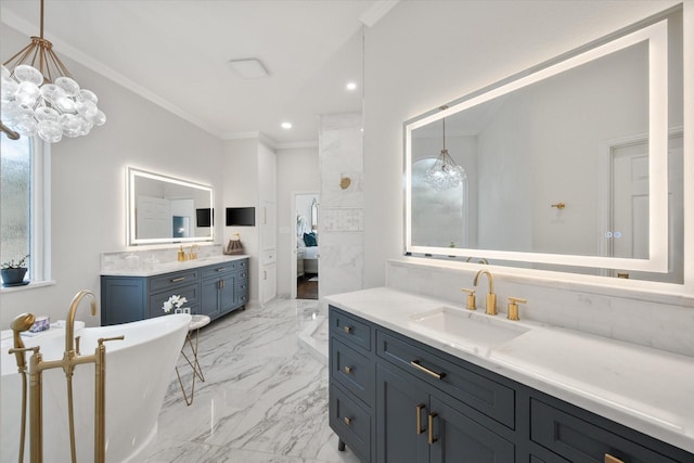 full bathroom featuring marble finish floor, an inviting chandelier, crown molding, a freestanding tub, and a sink