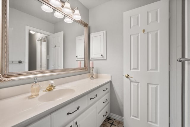 bathroom with baseboards, a notable chandelier, and vanity