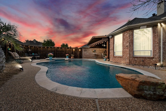 pool at dusk with a fenced in pool, a fenced backyard, and a patio