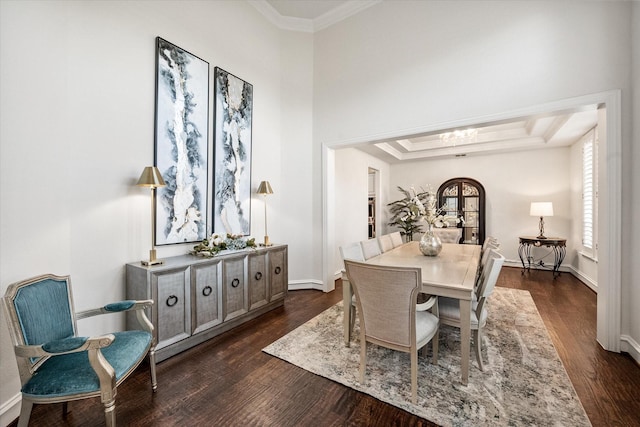 dining room featuring baseboards, a raised ceiling, dark wood-style floors, crown molding, and a notable chandelier