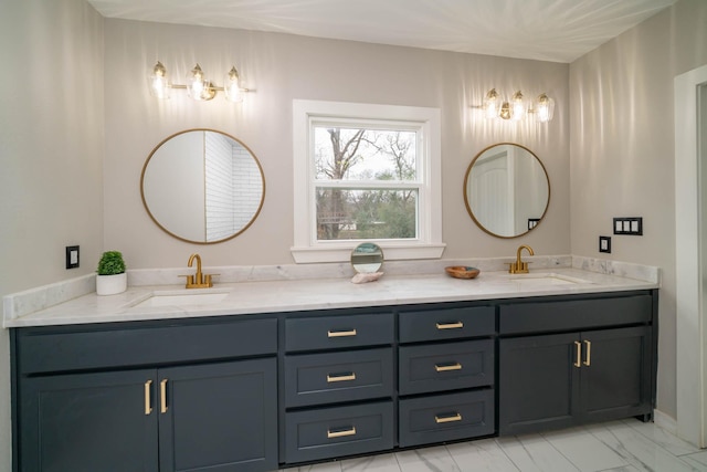 full bath featuring double vanity, marble finish floor, and a sink