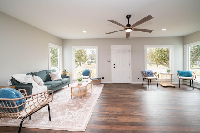 living area featuring recessed lighting, a healthy amount of sunlight, dark wood finished floors, and baseboards