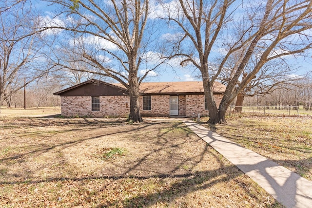 view of front facade with brick siding and fence