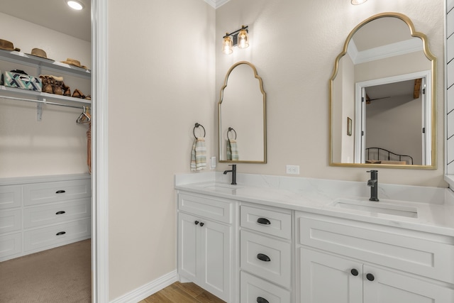 bathroom with double vanity, a sink, and baseboards