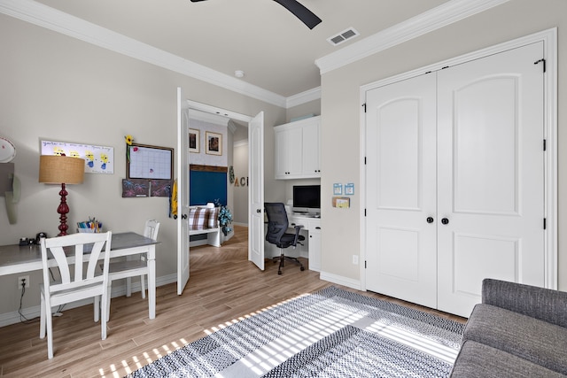 office area featuring baseboards, visible vents, built in study area, light wood-style flooring, and crown molding