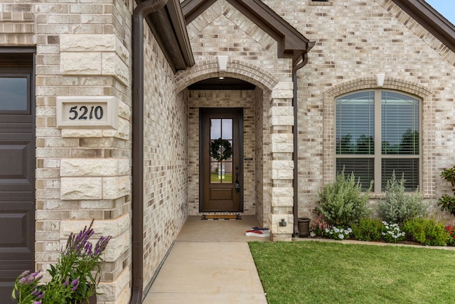 view of exterior entry featuring brick siding