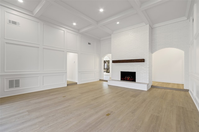 unfurnished living room with arched walkways, a fireplace, visible vents, and a decorative wall