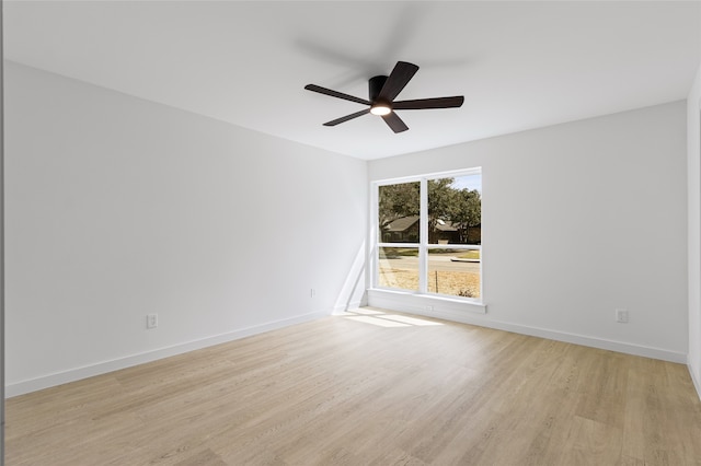 empty room with a ceiling fan, light wood-style flooring, and baseboards