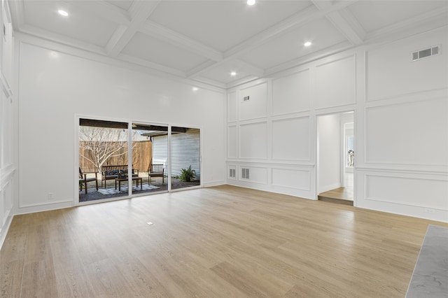 unfurnished living room with beam ceiling, visible vents, a decorative wall, light wood-style floors, and coffered ceiling