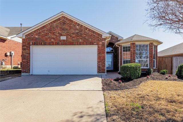 single story home featuring concrete driveway, brick siding, fence, and an attached garage