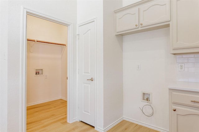 laundry room featuring hookup for a washing machine, light wood-type flooring, laundry area, and baseboards