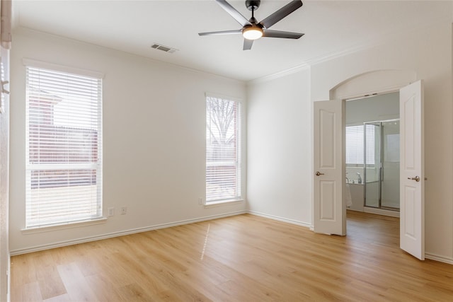 unfurnished room with visible vents, baseboards, light wood-style flooring, ceiling fan, and ornamental molding