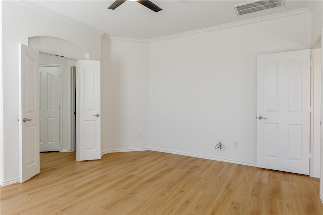 spare room with visible vents, light wood-style flooring, ornamental molding, ceiling fan, and baseboards