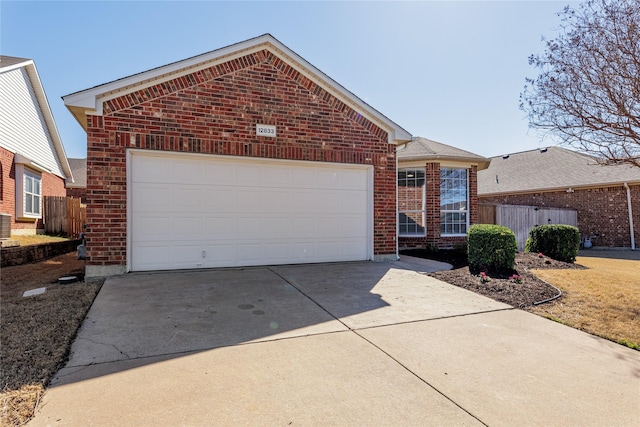 ranch-style home featuring a garage, concrete driveway, brick siding, and fence