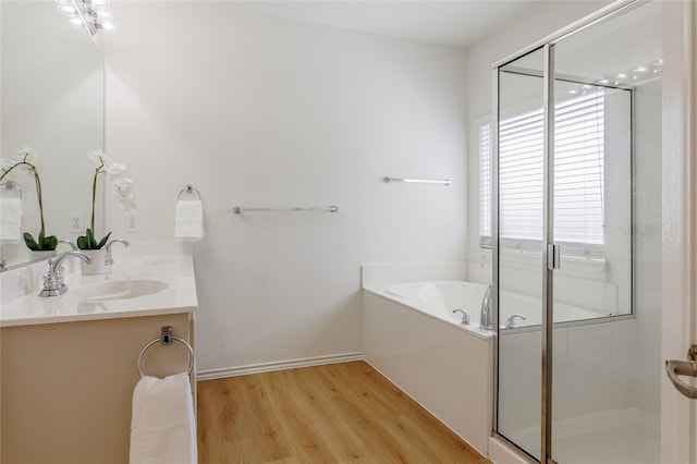 full bathroom featuring wood finished floors, a sink, a bath, and a shower stall