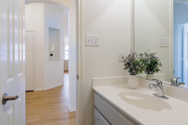 bathroom featuring vanity, baseboards, and wood finished floors