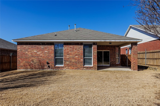 back of property with a patio area, a fenced backyard, a yard, and brick siding