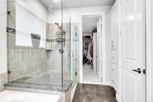 bathroom with a stall shower and a spacious closet