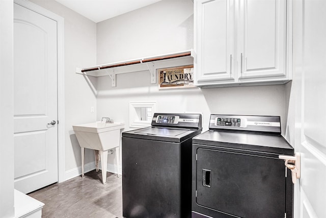 laundry room featuring baseboards, cabinet space, and washing machine and clothes dryer