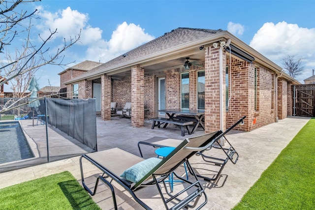 view of patio / terrace with a ceiling fan, a gate, and fence