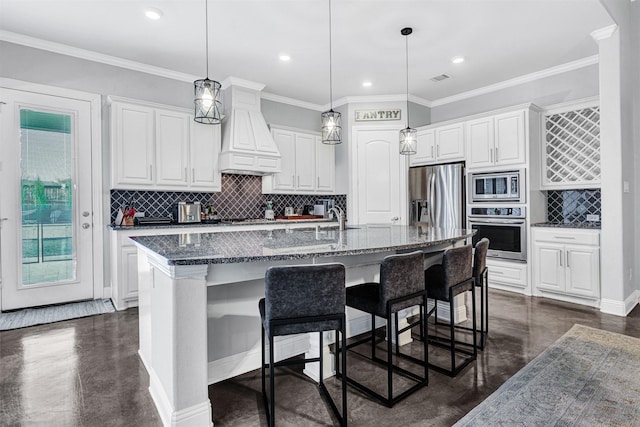 kitchen featuring stainless steel appliances, a kitchen breakfast bar, white cabinets, and custom exhaust hood