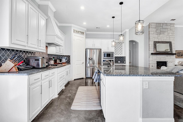 kitchen with stainless steel appliances, concrete floors, a sink, and decorative backsplash