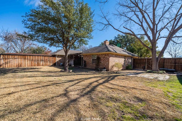 view of property exterior featuring a fenced backyard, a chimney, a lawn, and brick siding