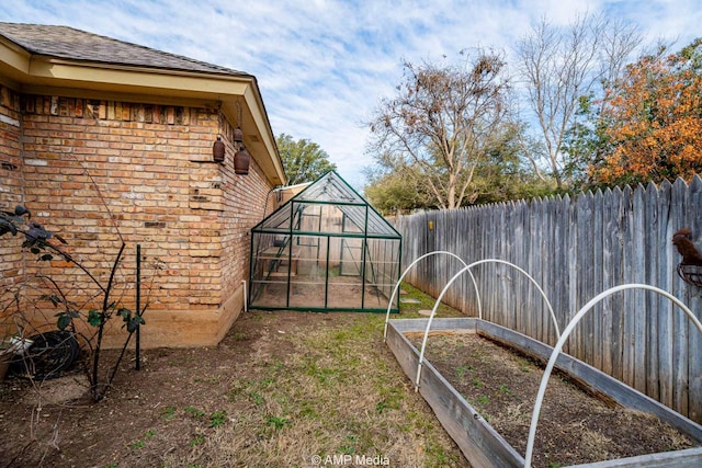 view of yard with fence private yard, an exterior structure, a vegetable garden, and an outdoor structure