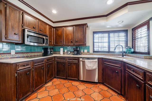 kitchen featuring light countertops, appliances with stainless steel finishes, a sink, and tasteful backsplash