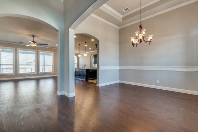 unfurnished room with dark wood-style floors, visible vents, ornamental molding, a ceiling fan, and baseboards