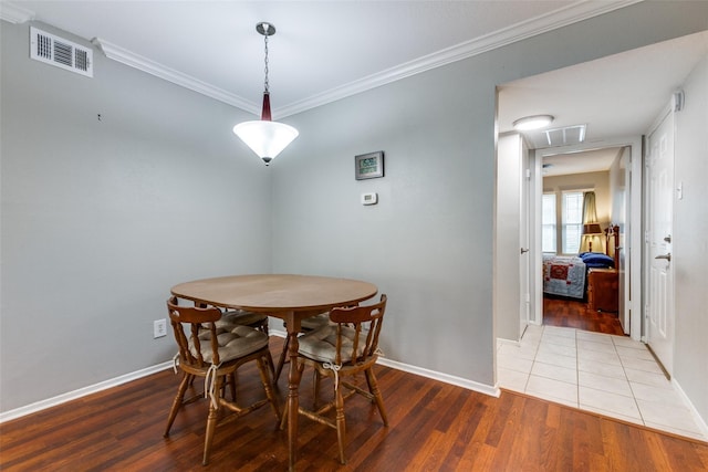 dining area with ornamental molding, visible vents, baseboards, and wood finished floors