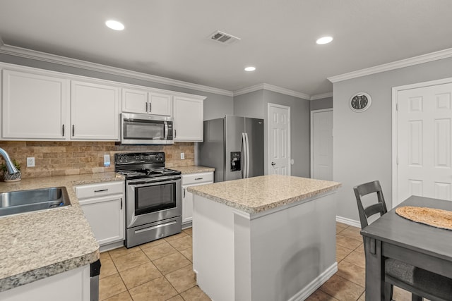 kitchen with stainless steel appliances, a sink, visible vents, and crown molding