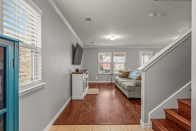 interior space featuring baseboards, visible vents, tile patterned flooring, stairs, and crown molding