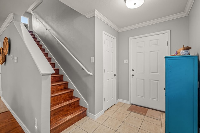 entrance foyer featuring crown molding, stairway, baseboards, and light tile patterned floors