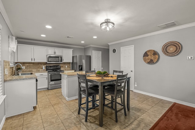 kitchen featuring appliances with stainless steel finishes, backsplash, a sink, and visible vents