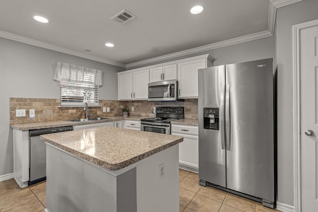 kitchen with appliances with stainless steel finishes, visible vents, a sink, and crown molding