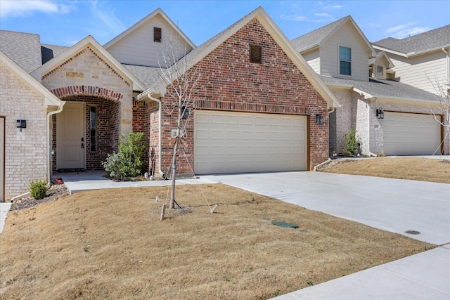 view of front of property featuring a garage, a shingled roof, concrete driveway, and brick siding