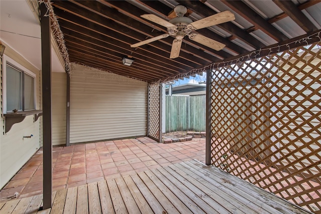 wooden terrace with ceiling fan, a patio area, and fence