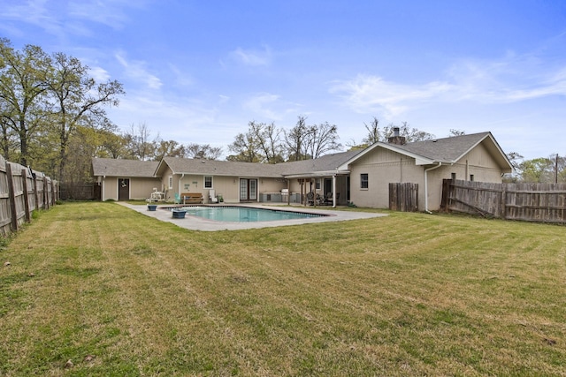 back of property with a fenced backyard, a fenced in pool, a lawn, and a patio