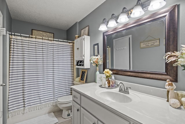 bathroom featuring toilet, tile patterned floors, a textured ceiling, and vanity