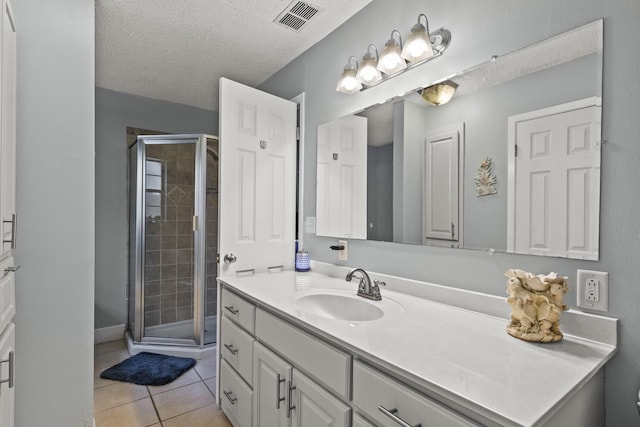 bathroom featuring visible vents, tile patterned floors, a textured ceiling, vanity, and a shower stall