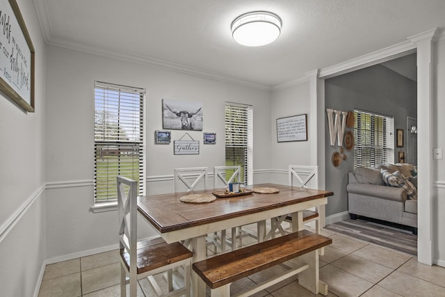 dining area featuring ornamental molding, light tile patterned flooring, and baseboards