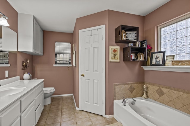 bathroom with tile patterned floors, baseboards, a bath, and vanity