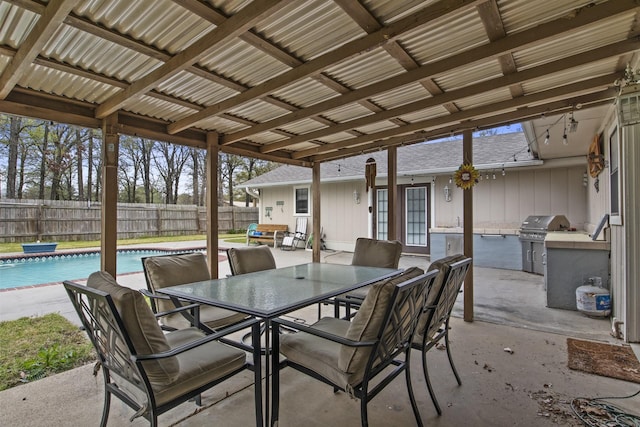 view of patio with outdoor dining area, area for grilling, fence, exterior kitchen, and a fenced in pool