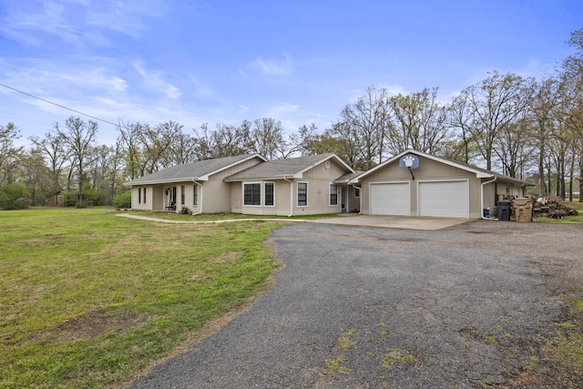 ranch-style house featuring a garage, aphalt driveway, and a front lawn