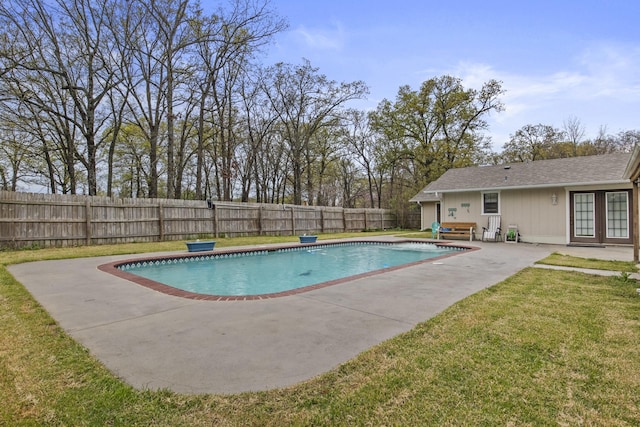 view of swimming pool with a patio, a fenced backyard, french doors, a lawn, and a fenced in pool