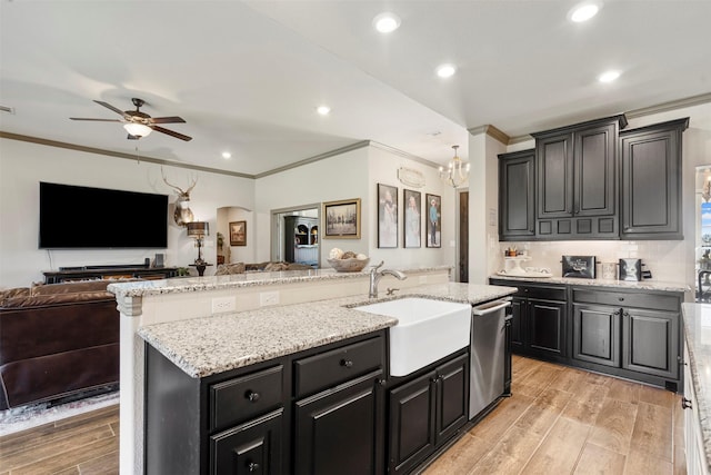 kitchen featuring open floor plan, a sink, light wood-style flooring, and stainless steel dishwasher